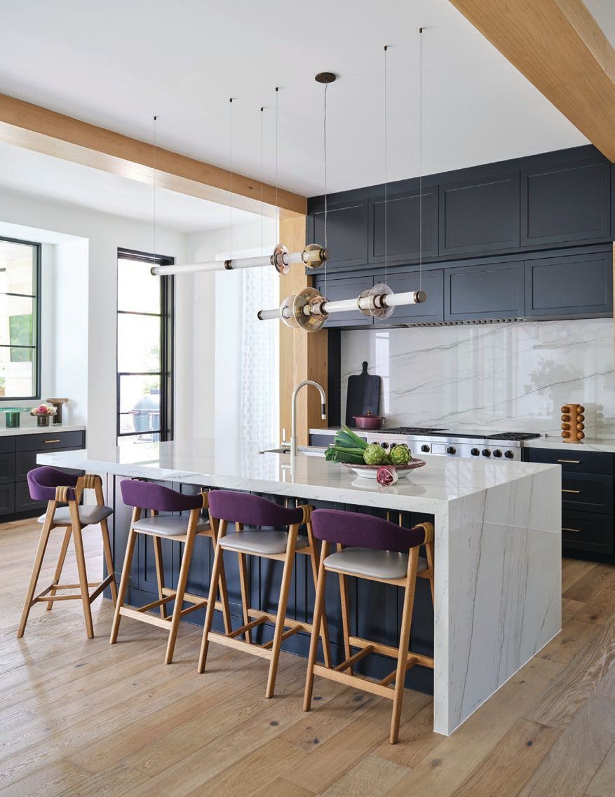 The open-plan kitchen hosts high beams from the ceiling as well as custom cabinetry PHOTOGRAPHY BY CODY ULRICH