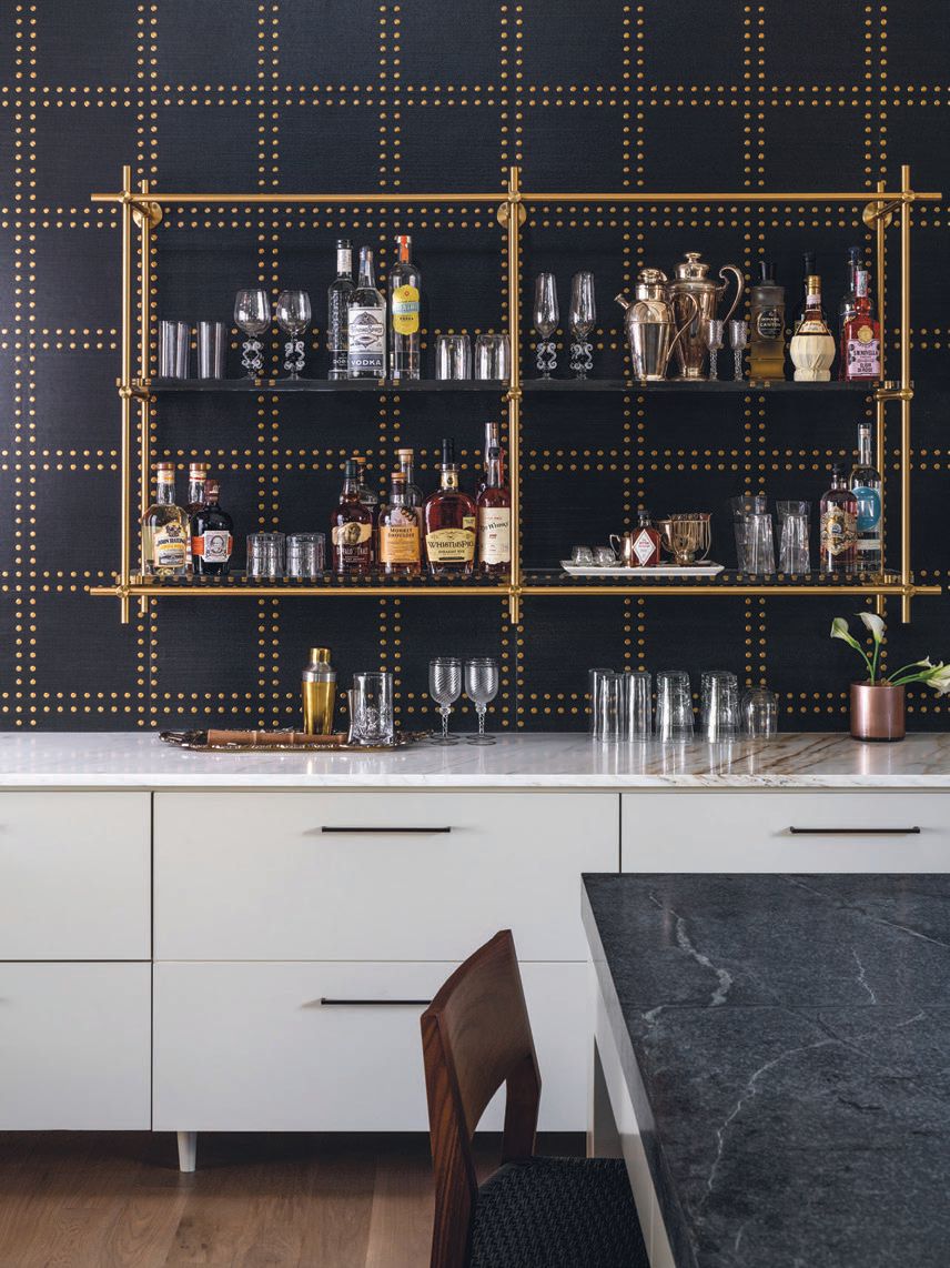 A patterned accent wall with rivets and bar shelving in the great room; PHOTOGRAPHED BY BLAKE VERDOORN