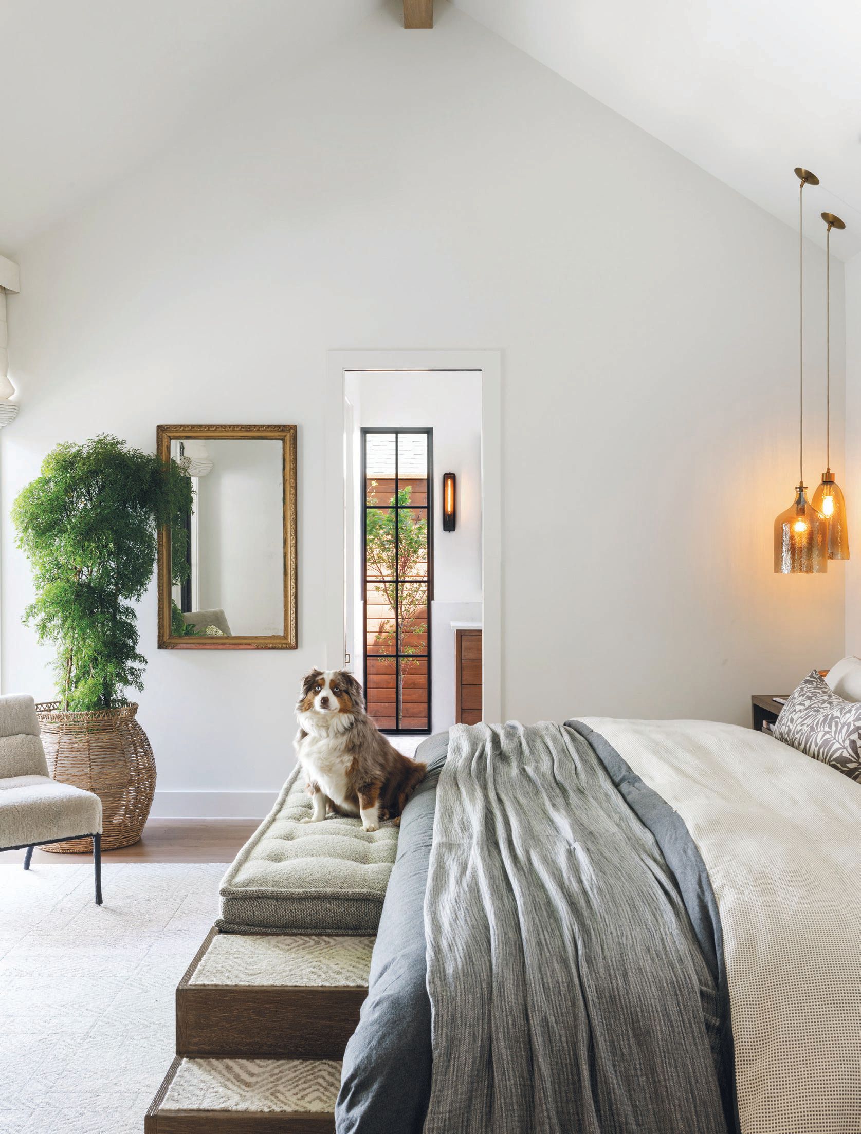 The primary bedroom’s large custom bed features a special staircase and bench for their beloved pooches. PHOTOGRAPHED BY BLAKE VERDOORN