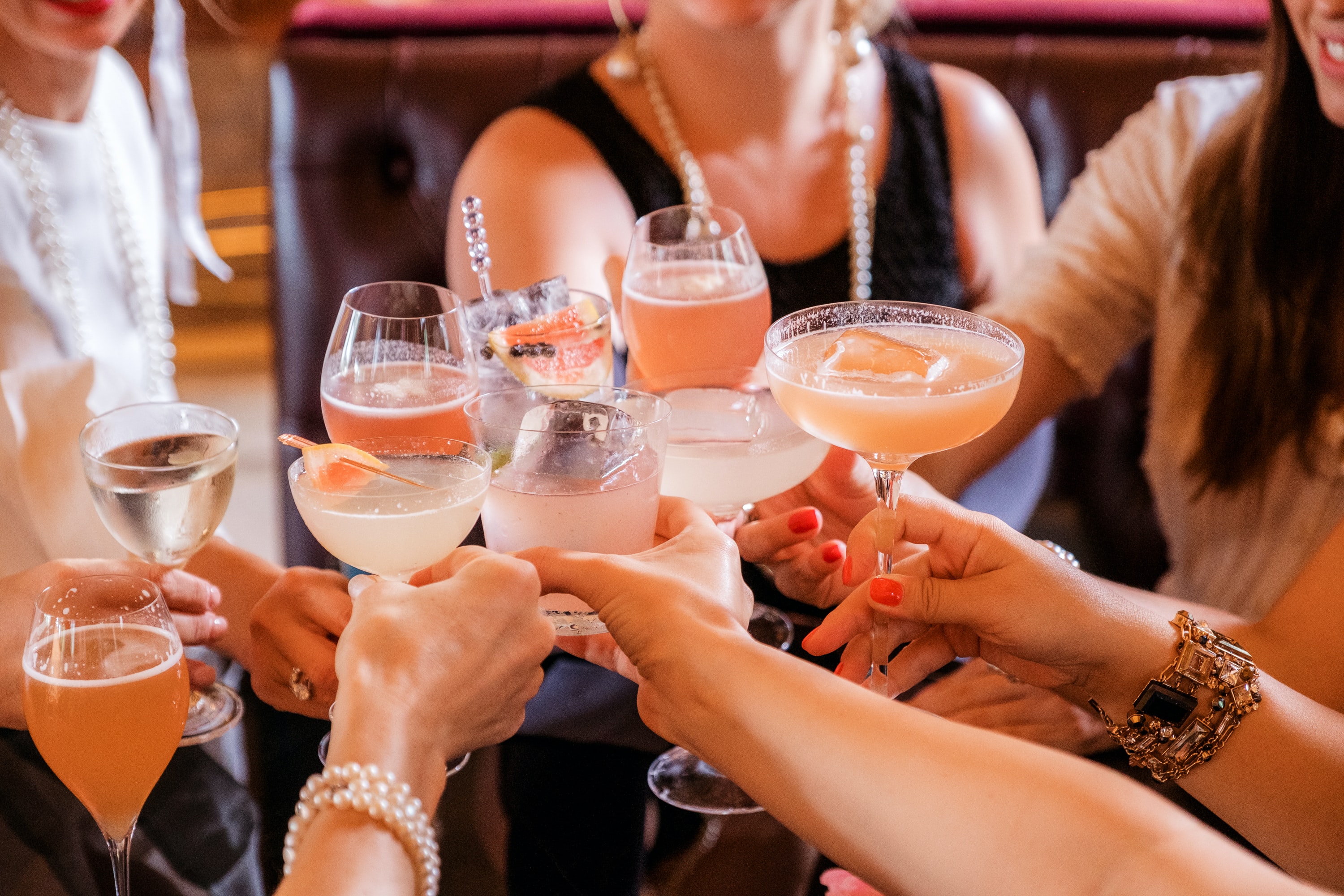 a group of people cheers with cocktails